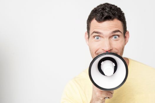 Excited man making advertisement in megaphone