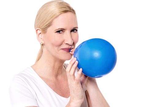 Beautiful woman blowing a blue balloon