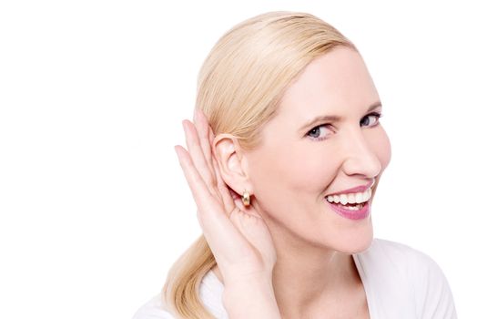 Listening woman holds her hand near ear 