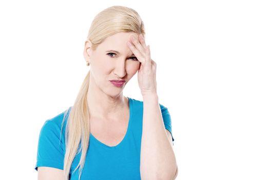 Depressed woman holding hand to forehead