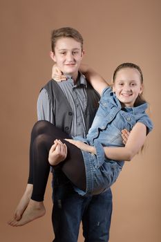 fashion smiling european little long hair blonde girl and her brother posing in atelier