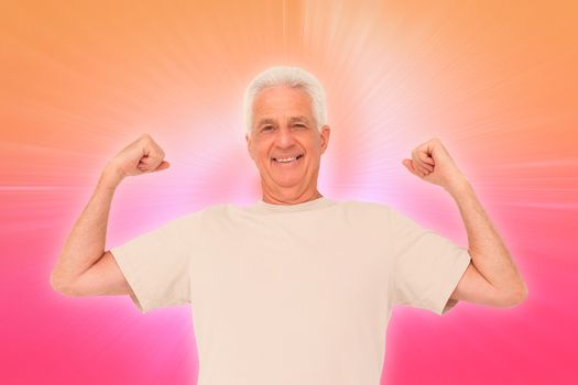 Senior man flexing his arms against abstract background
