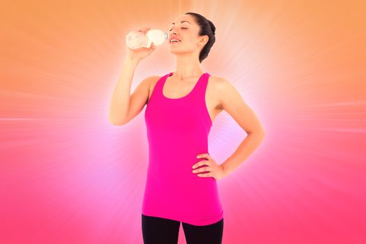Fit woman taking a drink against abstract background