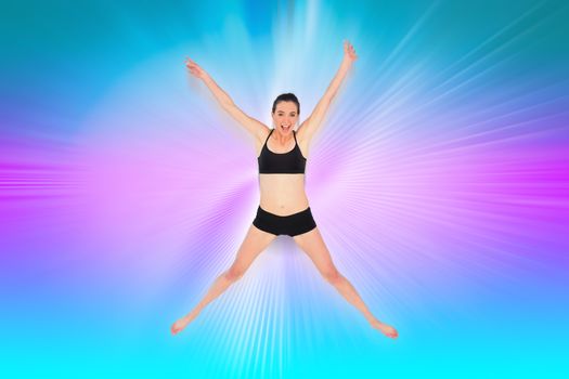 Full length of a sporty young woman jumping against abstract background