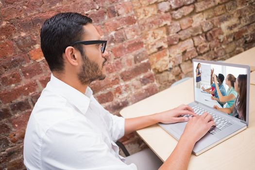 Casual business people in office at presentation against concentrated businessman using laptop at desk