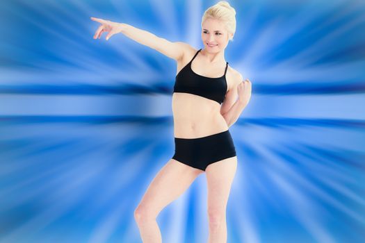 Full length of a sporty young woman pointing away against abstract background