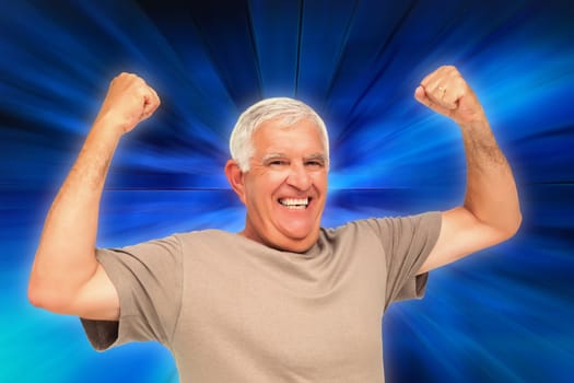 Portrait of a cheerful senior man with clenched fists against abstract background