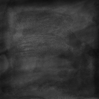 A cleaned blackboard. Wet sponge and chalk traces are visible. Background texture.