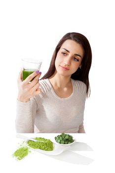 Beautiful smiling girl holding green juice in hand. Spirulina, chlorella and wheatgrass. Healthy lifestyle, detox.