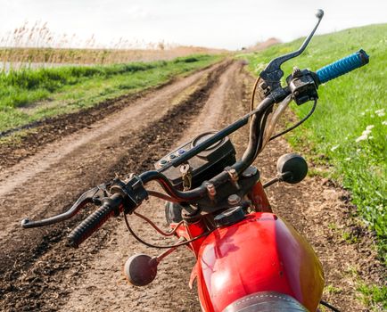 Classic old motorcycle on a dirt road. 