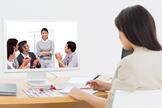 Portrait of a business team sitting together against rear view of a artist at desk with computer in office