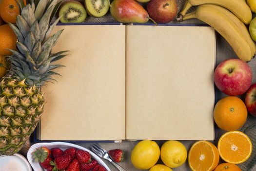 A selection of fresh fruit and a recipe book - Space for text