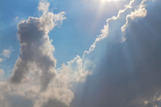 Sun under clouds on blue sky background