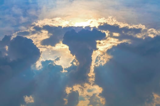 Sun under clouds on blue sky background