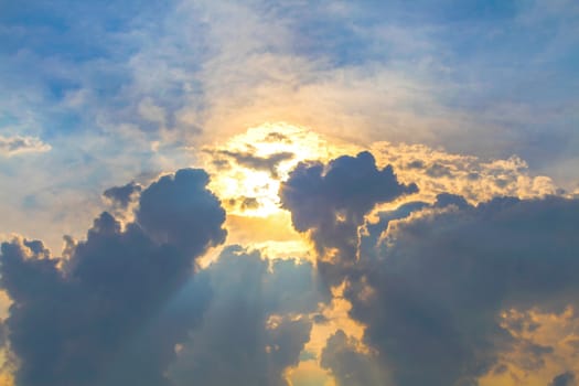 Sun under clouds on blue sky background