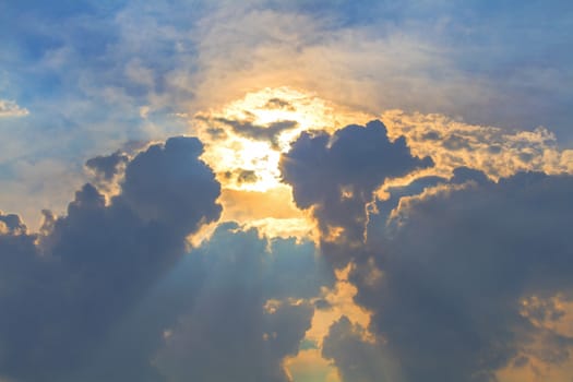 Sun under clouds on blue sky background