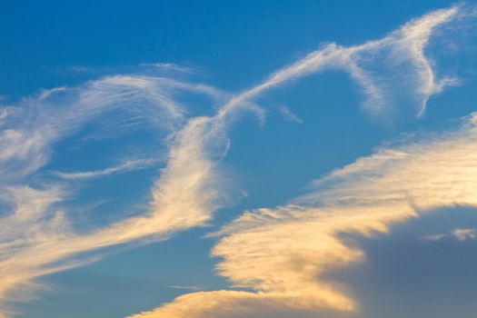 White and orange clouds on blue sky background