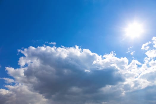 Sun and white clouds on blue sky background