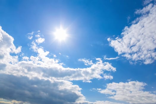 Sun and white clouds on blue sky background