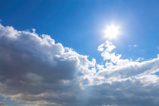 Sun and white clouds on blue sky background
