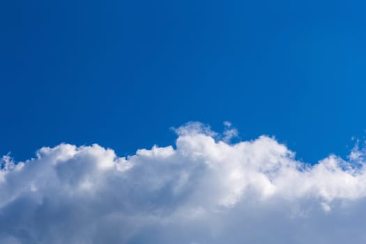 White fluffy clouds on blue sky background