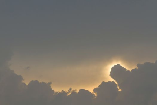 Sun under clouds on blue sky background