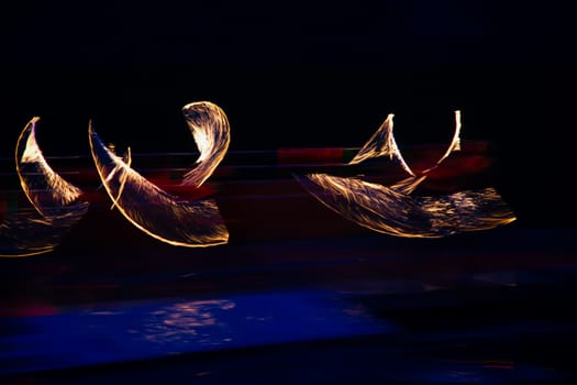 Fire performers in motion at night