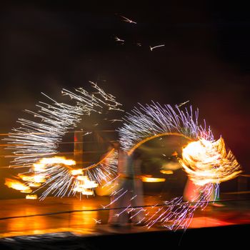 Fire performers in motion at night
