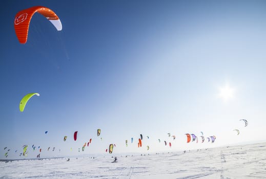 Kite surfer being pulled by his kite across the snow