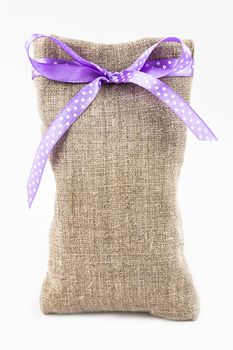 Decorative textile sachet pouch with a ribbon and bow on white background