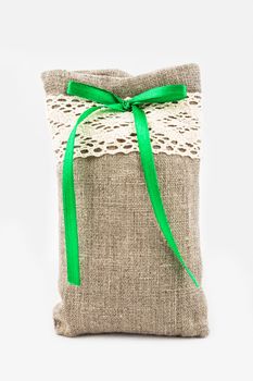 Decorative textile sachet pouch with a ribbon and bow on white background
