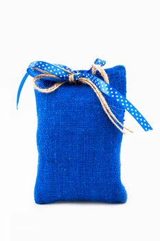 Decorative textile sachet pouch with a ribbon and bow on white background