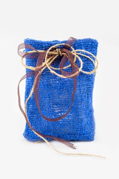 Decorative textile sachet pouch with a ribbon and bow on white background