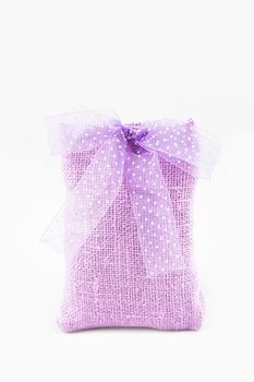 Decorative textile sachet pouch with a ribbon and bow on white background