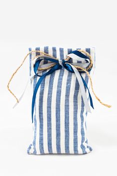 Decorative textile sachet pouch with a ribbon and bow on white background