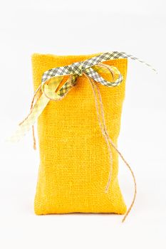 Decorative textile sachet pouch with a ribbon and bow on white background