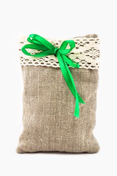 Decorative textile sachet pouch with a ribbon and bow on white background