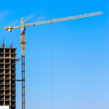 Construction crane on building site on sky background