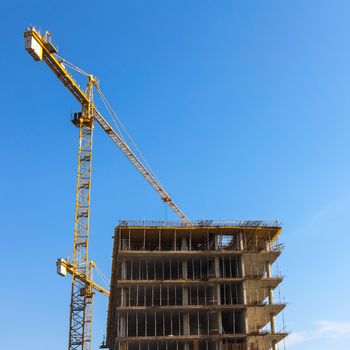 Construction cranes on building site on sky background