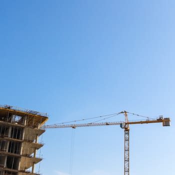 Construction crane on building site on sky background