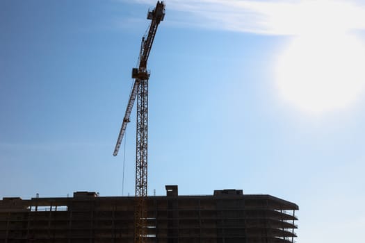 Construction crane on building site on sky background