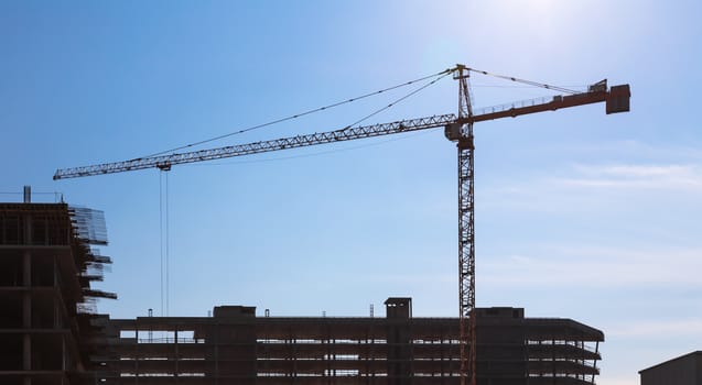 Construction crane on building site on sky background