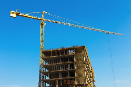 Construction crane on building site on sky background