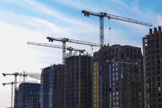 Construction cranes on building site on sky background