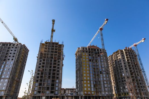 Construction cranes on building site on sky background