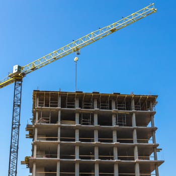Construction crane on building site on sky background