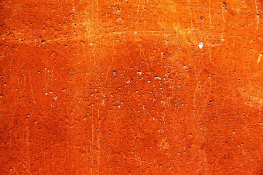 Grunge plaster cement or concrete wall texture orange color with scratches