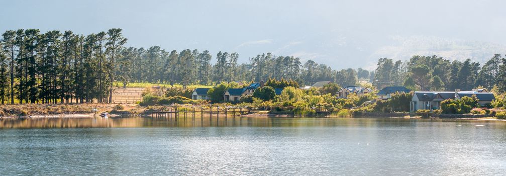 CAPE TOWN, SOUTH AFRICA - DECEMBER 18, 2014: Early morning panorama of houses next to a dam with jetty on the Wedderville Estate near Sir Lowrys Pass