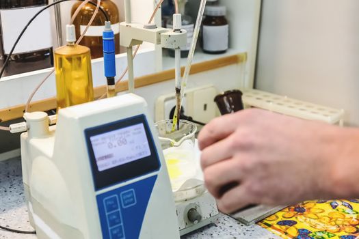Laborant makes test in research laboratory with electronic measuring equipment on pharmaceutical industry manufacture or chemical plant