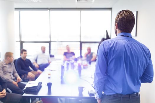 Business man making a presentation at office. Business executive delivering a presentation to his colleagues during meeting or in-house business training, explaining business plans to his employees.